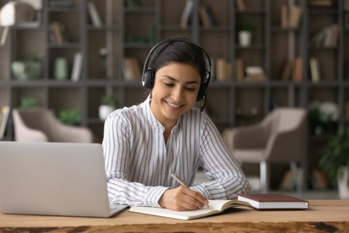 Happy beautiful Indian woman studying on online courses