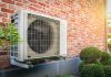 Air conditioning heat pump outdoor unit against brick wall