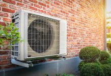 Air conditioning heat pump outdoor unit against brick wall