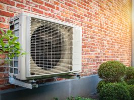 Air conditioning heat pump outdoor unit against brick wall