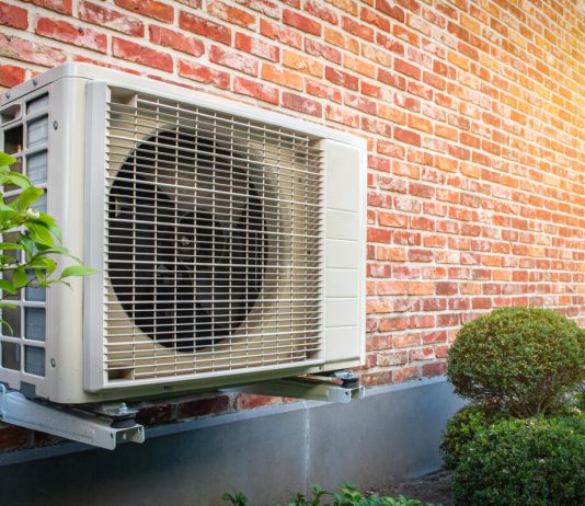 Air conditioning heat pump outdoor unit against brick wall