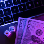 Online gambling with game dice on a laptop and dollars