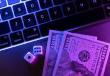 Online gambling with game dice on a laptop and dollars