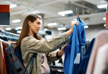 Young woman buying sweatshirt at clothing department.