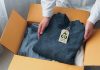 An environmentally conscious entrepreneur packs clothes made from natural materials into cardboard boxes to ship to customers