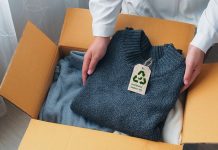 An environmentally conscious entrepreneur packs clothes made from natural materials into cardboard boxes to ship to customers