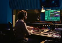 Control room sound engineer editing music with sliders and knobs