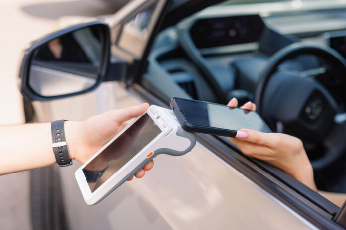 girl driver makes NFC payment with her mobile phone, contactless payment method for services