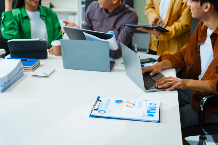 In a boardroom, an Asian team discusses startup financials and business terms.