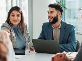 Business people and laptop with handshake in meeting