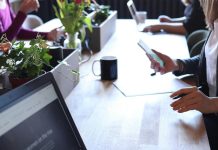 Person Holding Smartphone in Front of Table