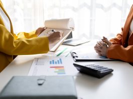 Business women working on desk office with using a calculator to calculate the numbers tax, finance accountingresearch or financial strategy in company