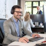 Smiling friendly handsome young male IT services operator.