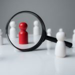 a magnifying glass looking to red wood people,Select a person in the team for a job