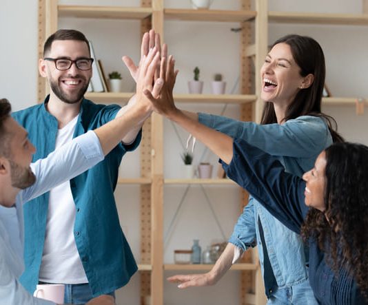 l employees give high five celebrate shared team business success in office.