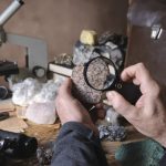 Geologist examining a mineral sample under a magnifying glass
