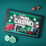 casino games online through an app with a tablet with a screen announcing that you play online casino on a table with green felt with betting chips and dice. Emotional Control in playing online casino