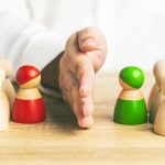 Red and green wooden figures teams against opponent or enemy. Office politics concept