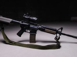 Army assault rifle with optical sight and tactical belt