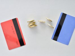 Bank cards are in the colors of living coral and blue with shiny yellow coins symbolizing the electronic exchange of money and balance.