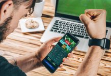 Lucky man celebrating victory after making bets on ICCWIN using gambling mobile application on his phone.