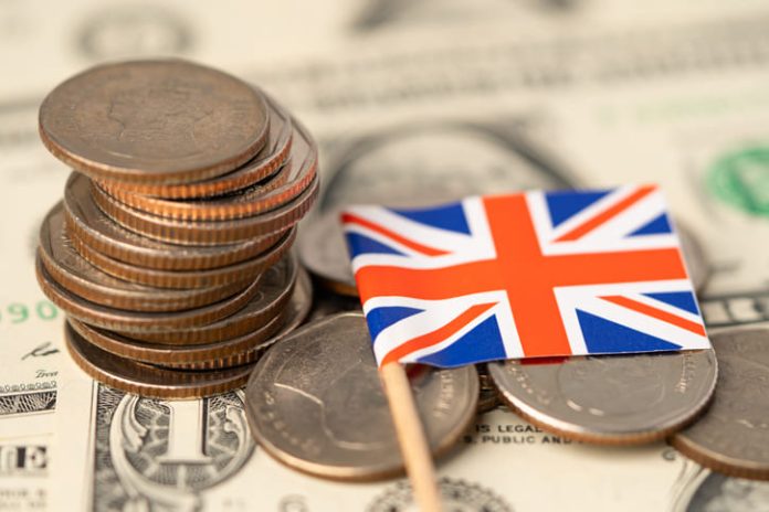 Loan providers in UK. United Kingdom Flag on coins background