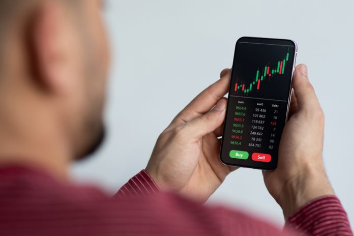 Middle-eastern businessman using trading application on smartphone for prop trading