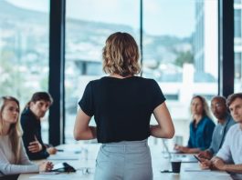 Woman addressing a meeting in office boardroom.