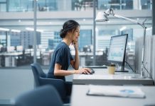 In Big Corporate Office: PR Business Manager Using Computer, Businesspeople and Experts Working Around Her, Analysing Statistics, Commerce Data, Marketing Plans.