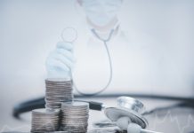 stethoscope checking stack of money coins arranged as a graph on wooden table,saving and manage money for healthcare, life insurance business technology and medtech