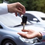 The car salesman and the key to the new owner.