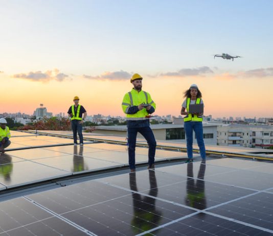 A team of engineers flies a drone to plan the installation of an outdoor solar panel system. Installing solar cells on the roof Solar panels on the roof Workers install eco-technology solar power plan.