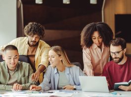 Diverse team of young Gen Z professionals collaborating on a project in a modern office