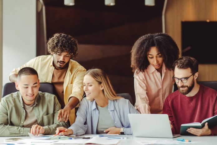 Diverse team of young Gen Z professionals collaborating on a project in a modern office