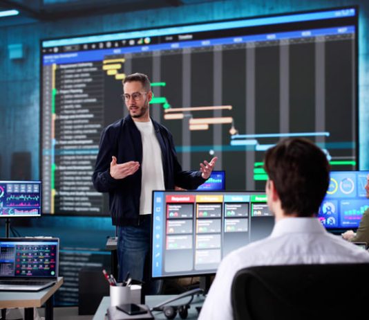 Multiracial executive training room presenting data