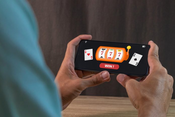 Man winning jackpot on online casino app on a smartphone. Online casino gambling development concept.